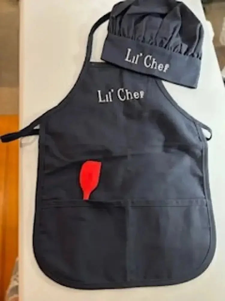 Personalized child apron and chef hat set in black with 'Lil' Chef' embroidery and red spatula