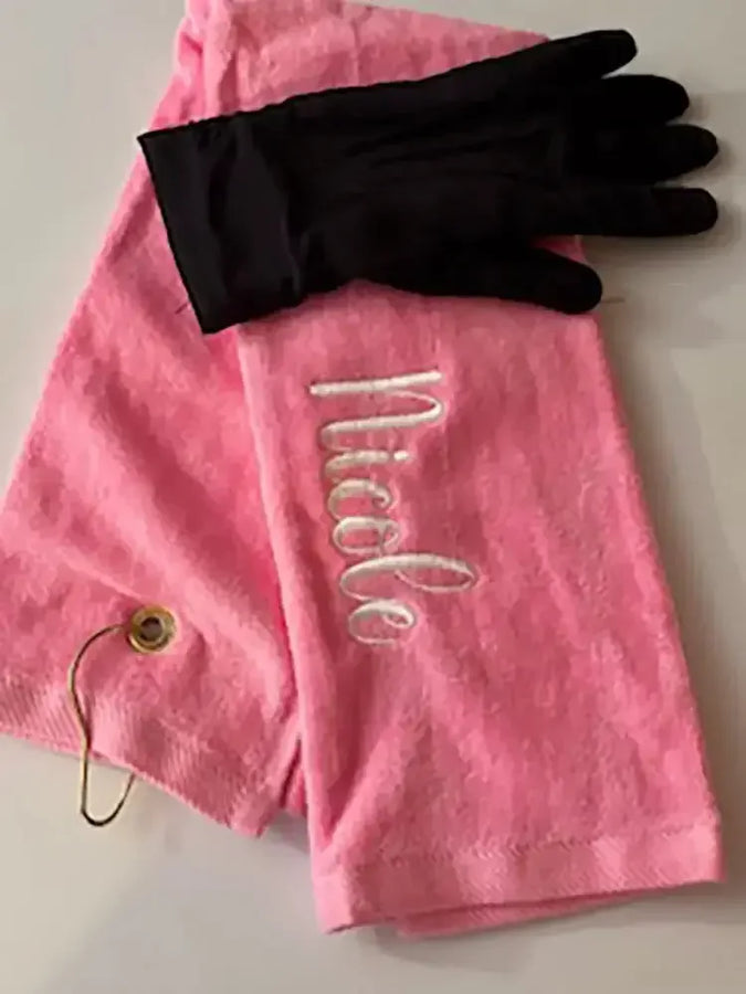 Personalized pink golf towel with embroidered name and black golf glove on white background