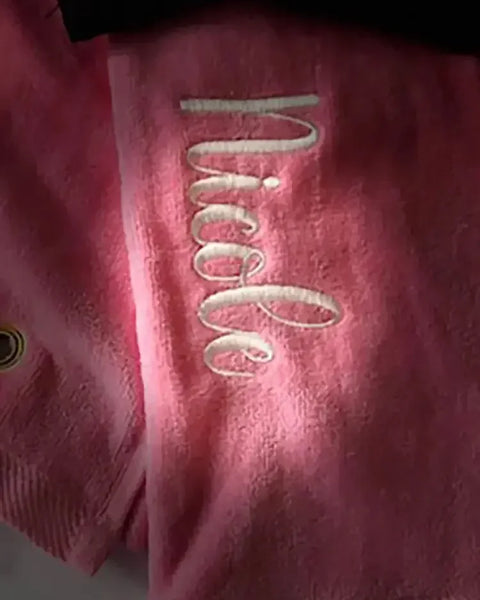 Pink personalized golf towel with embroidered name Nicole and metal grommet