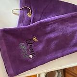 Purple embroidered golf towel with 'Queen of the Green' and crown design, gold clip attached