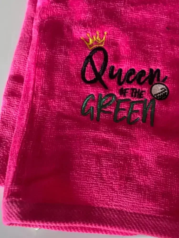 Pink embroidered golf towel with 'Queen of the Green' text, crown, and golf ball design.