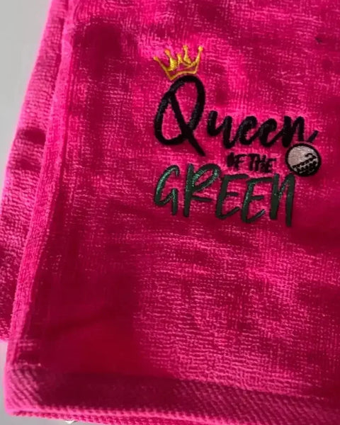 Pink embroidered golf towel with 'Queen of the Green' text, crown, and golf ball design.
