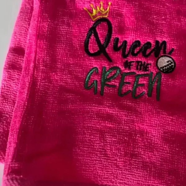 Pink embroidered golf towel with 'Queen of the Green' text, crown, and golf ball design.
