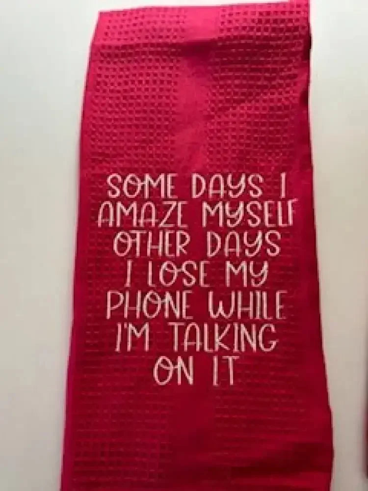 Red kitchen towel with humorous embroidered quote about losing a phone while talking on it