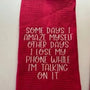 Red kitchen towel with humorous embroidered quote about losing a phone while talking on it
