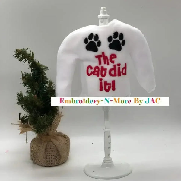 White elf sweater with 'The cat did it!' text, black paw prints, and mini Christmas tree.