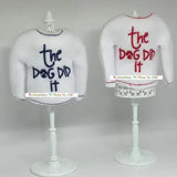 White elf sweaters with 'the dog did it' embroidered in blue and red on stands