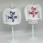 White elf sweaters with 'the dog did it' embroidered in blue and red on stands