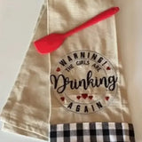 Embroidered kitchen towel with 'Warning! The girls are drinking again' and red spatula