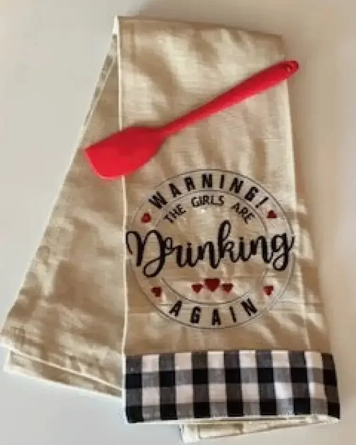 Embroidered kitchen towel with 'Warning! The girls are drinking again' and red spatula