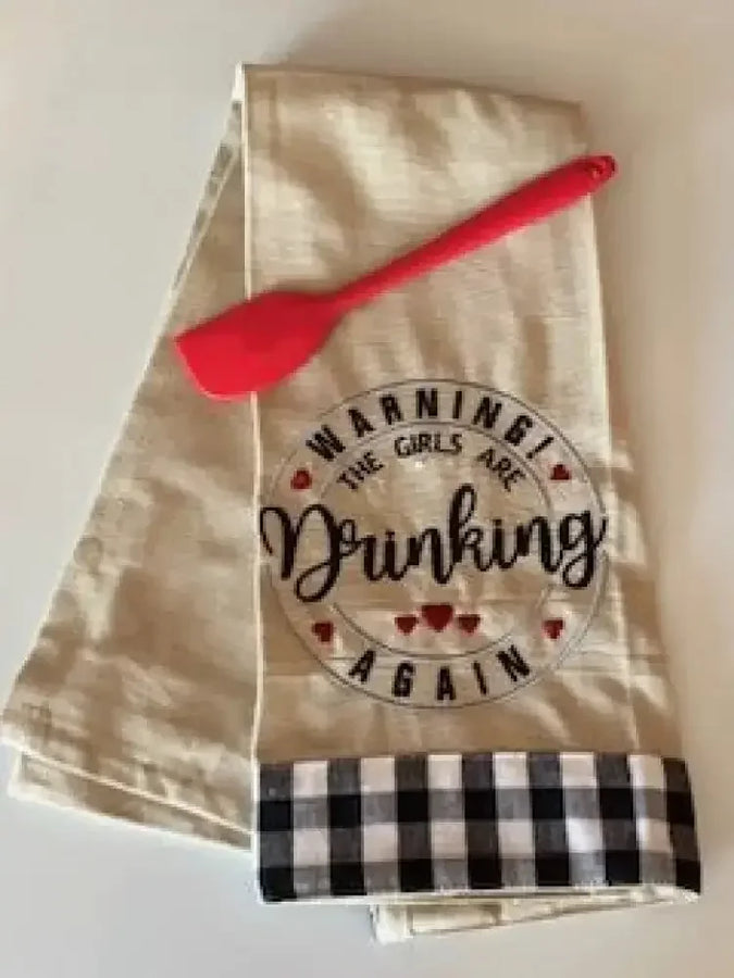 Embroidered kitchen towel with 'Warning! The girls are drinking again' and red spatula