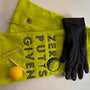 Yellow embroidered golf towel with 'Zero Putts Given' text, golf glove, tees, and ball